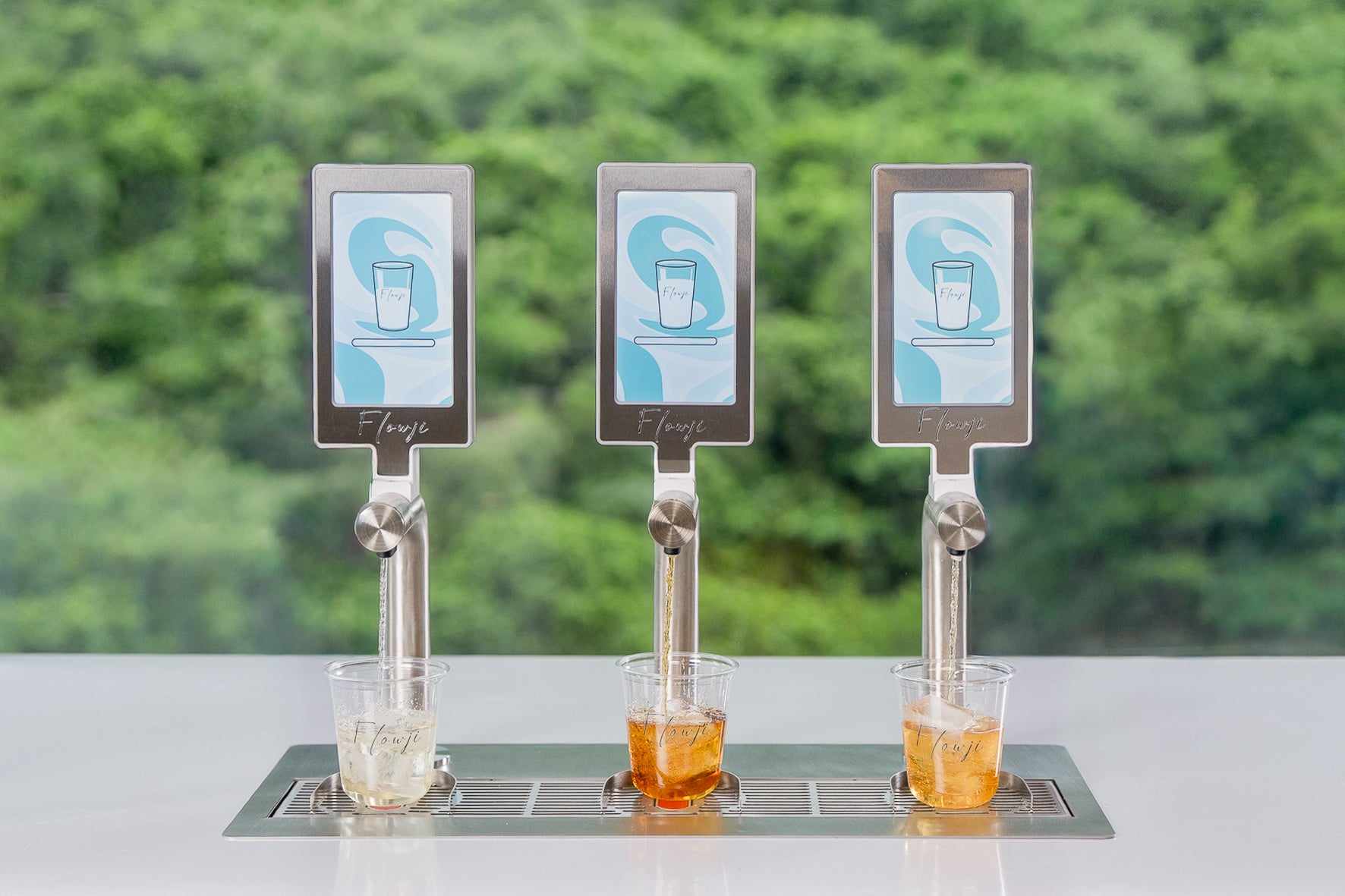 Flowji beverage cart dispensing handcrafted drinks into branded cups, showcasing live beverage preparation with three automated taps.