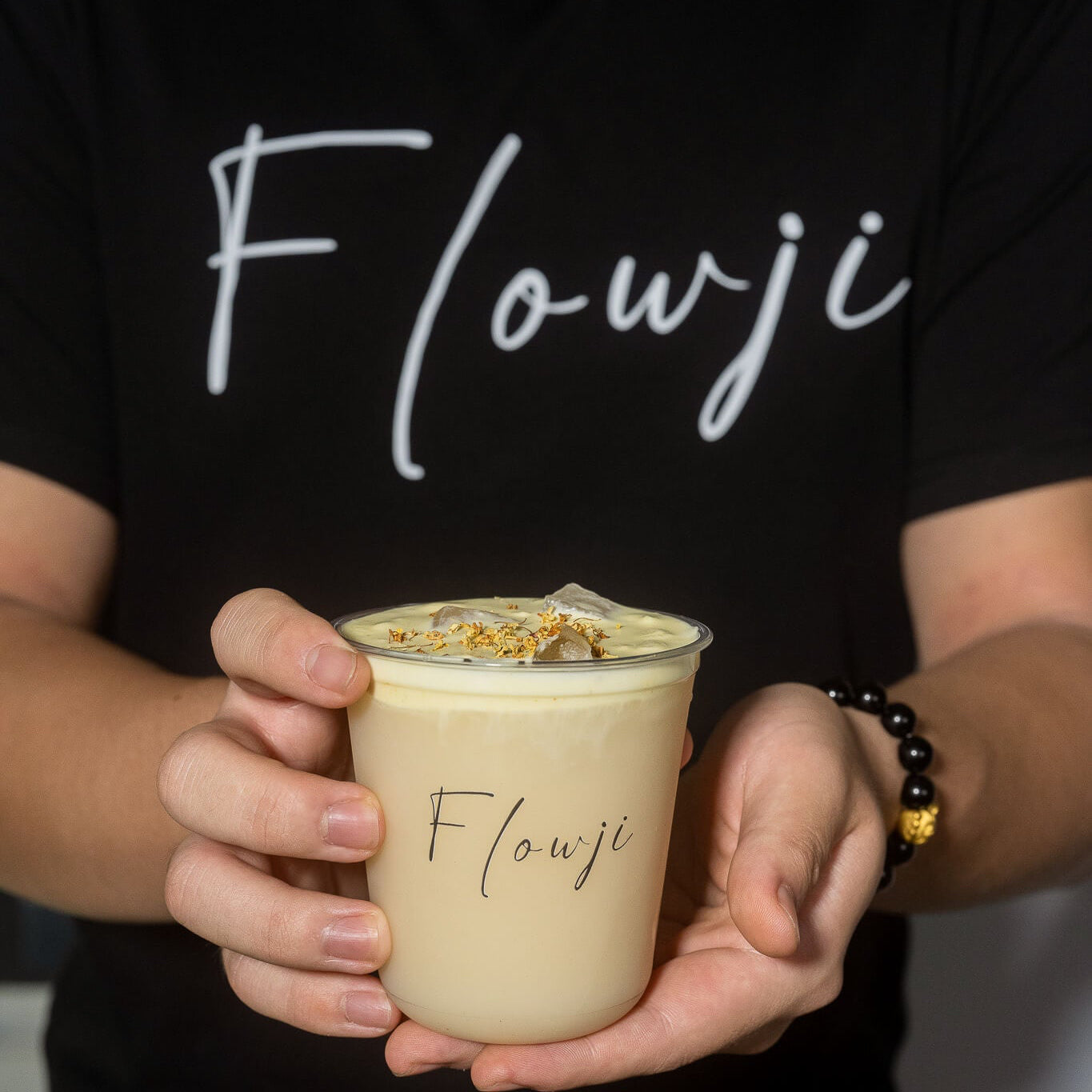 Flowji staff handing a freshly prepared signature drink to a guest, ready to enjoy at an event.