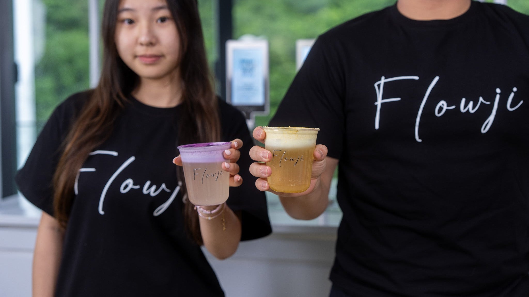 Flowji staff presenting handcrafted signature drinks in branded cups, showcasing premium mobile beverage catering for events.