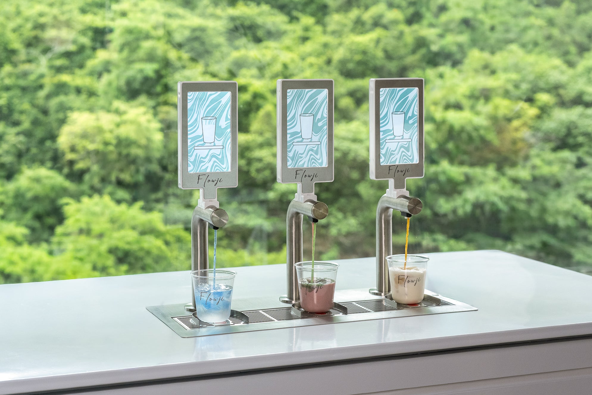 Flowji beverage cart dispensing freshly prepared drinks into branded cups through three automated taps during live event service.